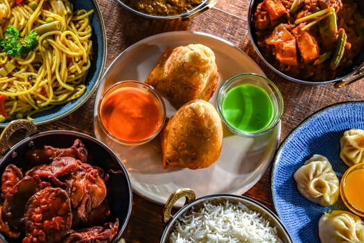 Composition with indian dishes: samosa, pakora, palak paneer, jalfrezi, thukpa and naan bread