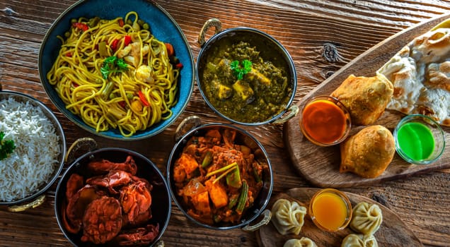 Composition with indian dishes: samosa, pakora, palak paneer, jalfrezi, thukpa and naan bread