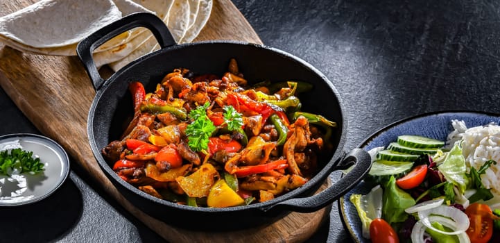 Fajita with stripped peppers and onions served on a hot iron skillet