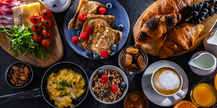 Breakfast served with coffee, orange juice, scrambled eggs, cereals, pancakes and croissants.