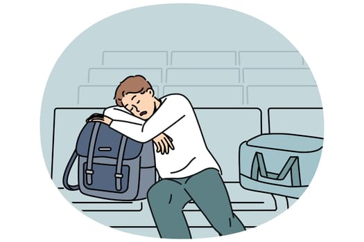 Sleeping man sits in lounge area at airport and waits for arrival of plane delayed due to bad weather. Tired guy airport passenger with bags and luggage waiting for flight and travel