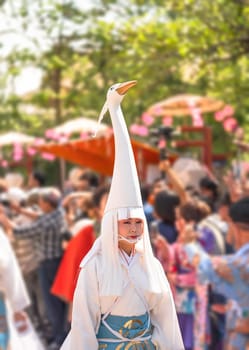 tokyo, asakusa - may 17 2024: A Japanese lady made up with traditional oshiroi blush wearing a heron head hat during the White Heron Dance Shirasagi-no-mai of Sanja Matsuri Festival at Sensoji Temple.