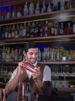Bartender is making cocktail with talking customer at bar counter