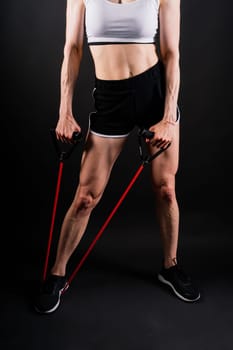 Athletic female performs exercises using resistance band. Strength and motivation