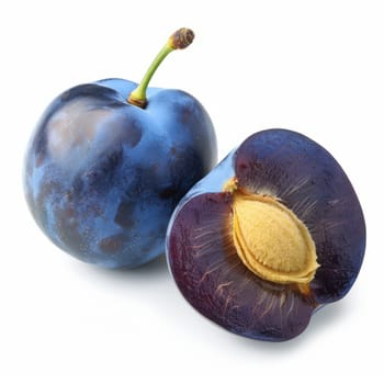 Fresh plums, one whole and one cut in half with visible seeds, bright purple-blue skin, yellow interior, isolated on white