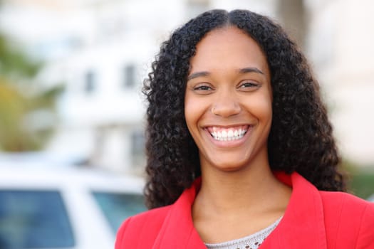 Front view portrait of a happy black woman with perfect smile in winter