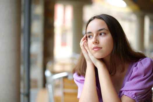 Pensive woman dreaming looking away in a cofee shop terrace