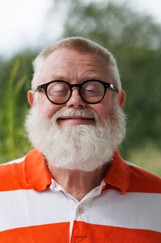 Senior with closed eyes looks into the future with a happy smile.