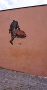Rimini, Italy - June 25, 2024: Mural on wall at Borgo San Giuliano typical street with low and colorful houses at Rimini, Italy