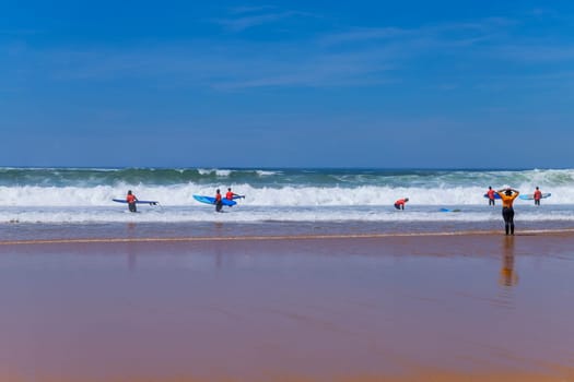 Ericeira, Portugal: April 13, 2024: Group of surfers with surfboards going to surfing. Ericeira is the famous surfing destination in Portugal.