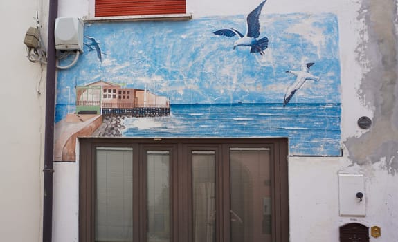 Rimini, Italy - June 25, 2024: Mural on wall at Borgo San Giuliano typical street with low and colorful houses at Rimini, Italy