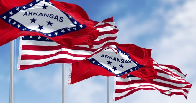 Arkansas state flags waving with the American flags on a clear day. 3d illustration render. Selective focus. Rippling fabric