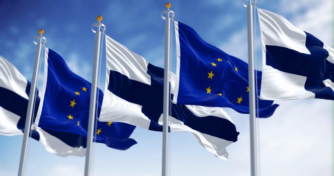 National flags of Finland waving in the wind with European Union flags on a clear day. 3d illustration render. Rippling fabric. Selective focus