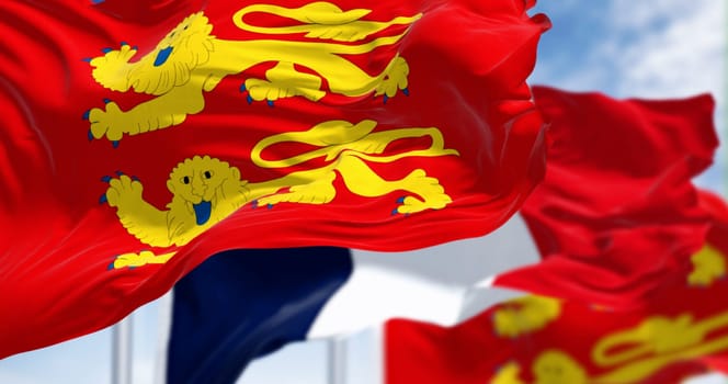 Flags of Normandy and France waving in the wind on a clear day. Normandy is a region in northern France. 3d illustration render. Rippling textile