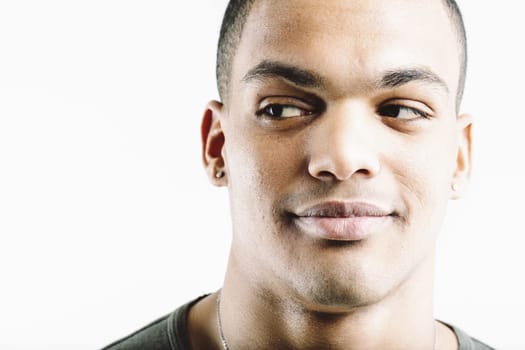 Young man in a green shirt, looking sideways with a subtle smile. His expression suggests a mix of curiosity and amusement, giving a confident yet playful vibe