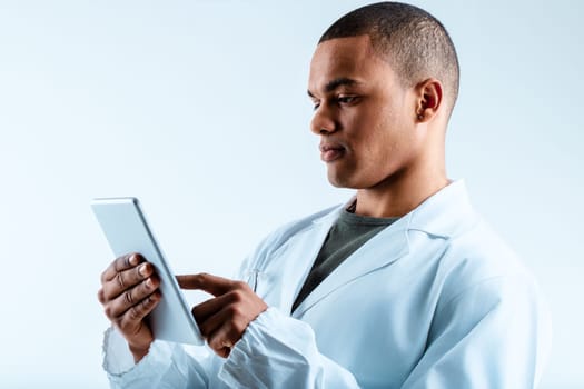 Man in a white lab coat, using a digital tablet, focuses on deep learning and LLMs. His serious demeanor highlights his dedication to data science, big data, and statistical analysis
