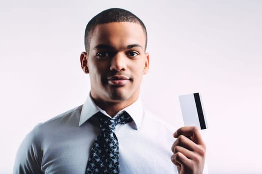 Young man in a white shirt and patterned tie, holding out a business card. His confident expression and professional attire suggest he is ready for networking or business interactions