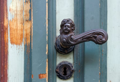 Antique door handle on a old door in detail.