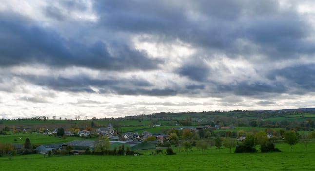 a landscape of normandy countryside, cloudy sky