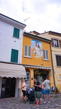 Rimini, Italy - June 25, 2024: Mural on wall at Borgo San Giuliano typical street with low and colorful houses at Rimini, Italy