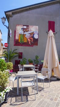 Rimini, Italy - June 25, 2024: Mural on wall at Borgo San Giuliano typical street with low and colorful houses at Rimini, Italy