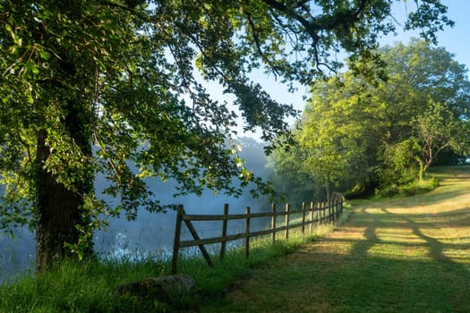 a sunrise in the mist over the pond