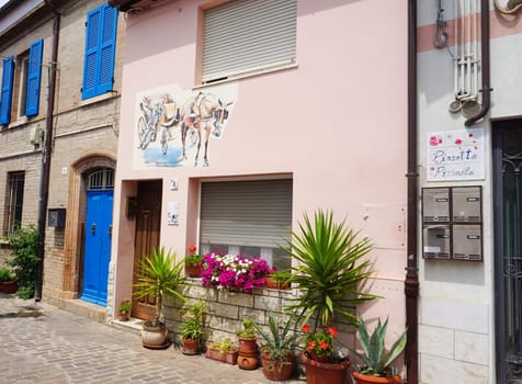 Rimini, Italy - June 25, 2024: Mural on wall at Borgo San Giuliano typical street with low and colorful houses at Rimini, Italy