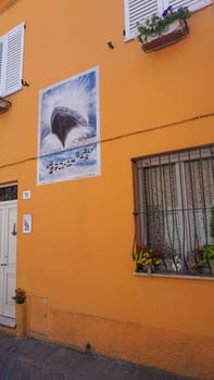 Rimini, Italy - June 25, 2024: Mural on wall at Borgo San Giuliano typical street with low and colorful houses at Rimini, Italy