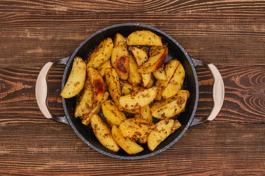 Potato wedges roasted in oven with thyme and salt, top view