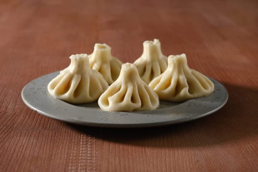 Traditional Georgian dish khinkali stuffed with lamb of beef meat on ceramic plate