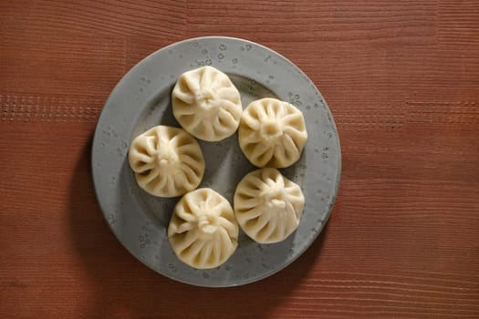 Overhead view of a plate with traditional Georgian dish khinkali stuffed with lamb of beef meat