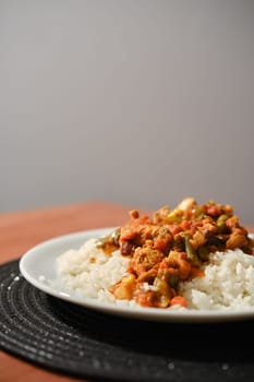 Close-up view of chicken ragout with vegetables and rice served on a plate