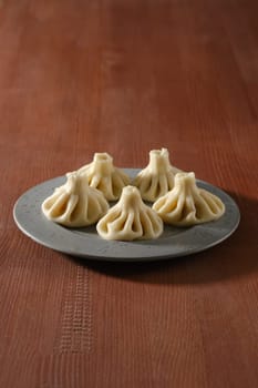 Georgian boiled dumplings - khinkali stuffed with lamb or beef minced meat on a plate