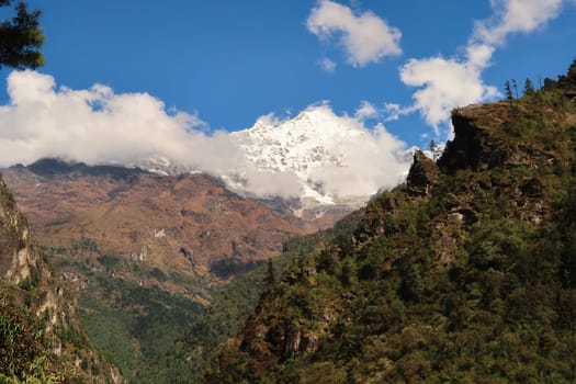 View on to the snow covered peak of Mount Thamserku seen on the trail between Tok Tok village and Benkar village on the Mount Everest Basecamp Trek, EBC, Nepal 2022