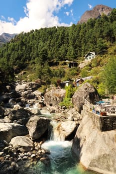 View from a bridge close to the Tok Tok village, a river with intense green water and big rocks and a terrace right next to it, Mount Everest Basecamp Trek, EBC, Nepal 2022
