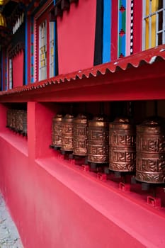 The copper prayer wheels on the colorful facade of the monastery in Monjo, Manjo village, Mount Everest Basecamp Trek, EBC, Nepal 2022