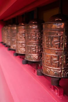The copper prayer wheels on the bright red facade of the monastery in Monjo, Manjo village, Mount Everest Basecamp Trek, EBC, Nepal 2022