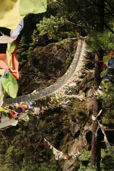The famous Hillary suspension bridge between Phakding and Namche Bazar, Bazaar, the wind is moving the many colorful prayer flags attached to it, Mount Everest Basecamp Trek, EBC, Nepal 2022