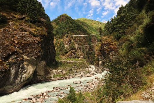 View onto the Hillary suspension bridge, a double suspension bridge over the Dudh Khosi River between Phakding and Namche Bazar, Bazaar, Mount Everest Basecamp Trek, EBC, Nepal 2022