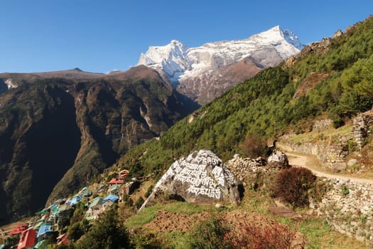 On the trail above Namche Bazaar, Bazar with the Kongde Ri peak in the background and a Mani Stone in the foreground, Mount Everest Basecamp Trek, Nepal 2022