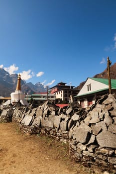 Hundreds of Mani stones stacked in piles at Tengboche, Tangboche village, the monastery and a stupa, pagoda can be seen in the background, Mount Everest Base Camp Trek, EBC, Nepal 2022