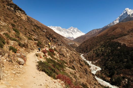 On the trail along the Imja Khola River, a part of Mount Ama Dablam can be seen on the right, the village of Shomare in front of Mount Nuptse, Everest and Lhotse in the background, Mount Everest Base Camp Trek, EBC, Nepal 2022