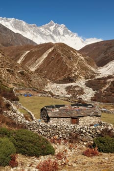 A traditional stone farmhouse with slate roof between Pangboche and Dingboche surrounded by stone walls with Mount Nuptse and Lhotse in the background, Mount Everest Base Camp Trek, EBC, Nepal 2022