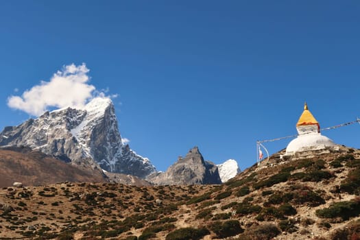 A stupa, pagoda on a steep hill in front of the peak of Mount Tobuche, Dingboche village, Mount Everest Base Camp Trek, EBC, Nepal 2022