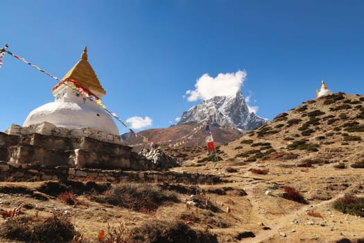 Two stupas, pagodas in a steep hill in front of the peak of Mount Tobuche, Dingboche village, Mount Everest Base Camp Trek, EBC, Nepal 2022