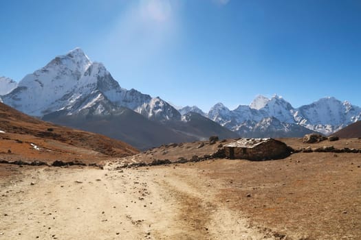 An old traditional stone farmhouse with slate roof in front of Mount Amphu Gyabjen, Ama Dablam, Kangtega and Thamserku, close to Dingboche, Pheriche village, Mount Everest Base Camp Trek, EBC, Nepal 2022