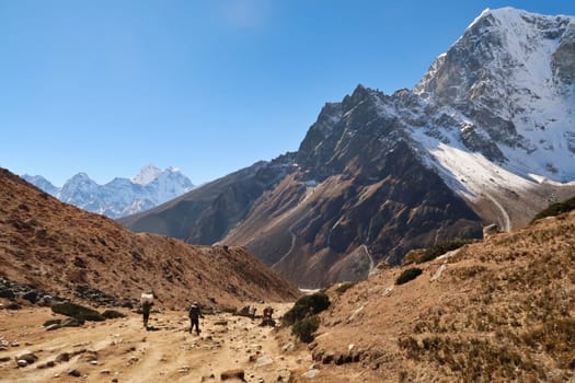 Walking down from Dughla, Thukla village into the valley of Pheriche village, Mount Kangtega, Thamserku, Tobuche in the background, Mount Everest Base Camp Trek, EBC, Nepal 2022