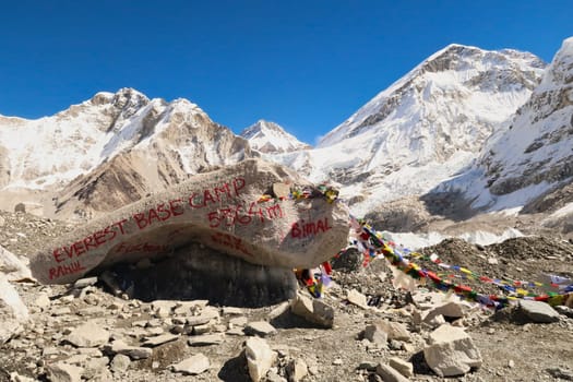 At the Base Camp of Mount Everest, a large rock, boulder, sprayed with red graffiti, paint marks the site, Mount Khumbutse, Changtse, the West Ridge of Everest and Everest in the background, Mount Everest Base Camp Trek, EBC, Nepal 2022