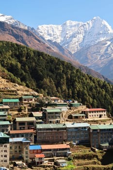 View onto a colorful neighborhood of Namche Bazaar, Bazar with Mount Kusum Kanguru, Kangguru rising in the background, Mount Everest Base Camp Trek, EBC, Nepal 2022