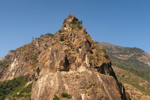 View from the trail onto a giant boulder, rock, that has a part of the road from Besisahar, Bhulbhule to Chame, Manang carved into it, close to Tal village, Annapurna Circuit Trek, Nepal 2022